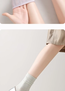 Close-up of breathable mesh texture and delicate wavy lace edges on silk crew socks