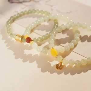 Detailed macro view of Hetian jade beads and gold charms on elegant Chinese style bracelets