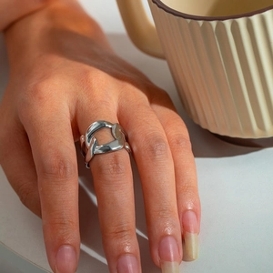 Close-up of a silver chain-link stainless steel ring worn on a finger for a modern style