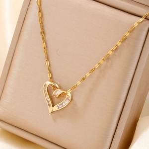 Macro detail of gold heart pendant necklace with zircon inlay in a premium jewelry box