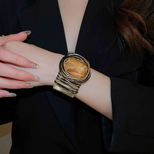 Détail d'un bracelet manchette multicouche torsadé avec cristal ambré facetté