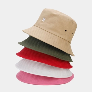Détail du tissu en toile de qualité et du logo N brodé sur des bobs de différentes couleurs