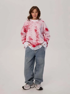 Oversize distressed knit sweater with red gradient splash print and ripped cuffs