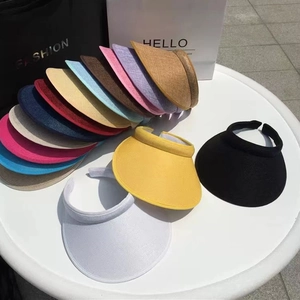 Outdoor scene showing various color options of woven open-top sun hats on a table