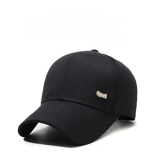 Detailed view of the silver 'Sport' metal emblem on the side of a black cotton baseball cap