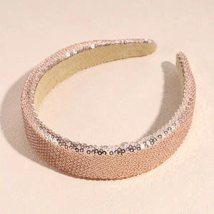 Primer plano de la diadema de lentejuelas oro rosa brillante con forro beige suave