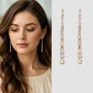 Boucles d'oreilles longues à pompons de perles et zircons sur fond noir élégant