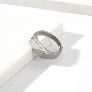Minimalist silver stainless steel signet ring with flat rectangular top on white block
