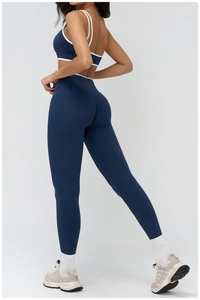 Detail of navy blue yoga set showing high-waisted leggings and contrast trim sports bra