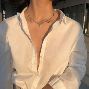 Collana in argento con ciondoli a farfalla blu indossata con luce naturale calda