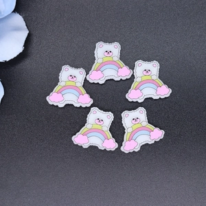 Close-up of five DIY cartoon bear and rainbow resin patches for phone case decoration