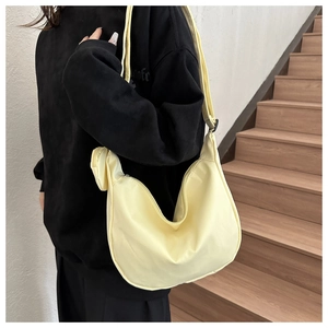 Detail showing the light yellow nylon crescent bag texture and sturdy metal zipper