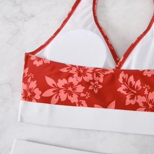 Detail of red and white floral print bikini top with removable pads on marble background