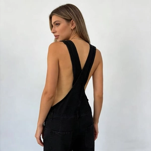 Detail of cross-back strap design on casual black denim overalls with a low-back cut