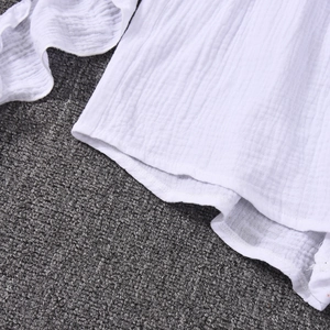 Close-up of white breathable double gauze cotton fabric with fringe detail and soft texture