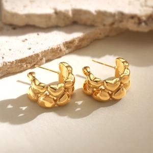 Minimalist gold plated stainless steel double heart C-shaped hoop earrings on stone display