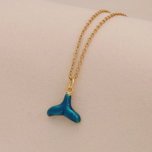 Detail of whale tail pendant with blue-green enamel on a golden stainless steel chain