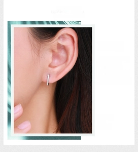 Close-up of S925 sterling silver hoop earrings with white zircon stones on model's ear