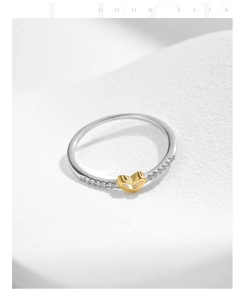 Macro detail of S925 silver heart ring with sparkling pavé zircons and gold hollow heart