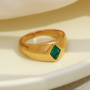 Close-up of a chunky 18K gold plated ring with a geometric rhombic malachite stone inlay