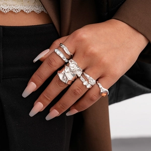 Close-up of silver-tone ring set with lava texture and resin stones on model's hand
