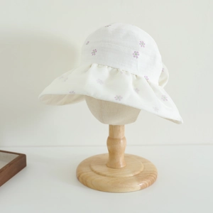 Detail of wide brim sun hat for girls with purple floral print and wavy ruffled edge