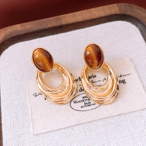 Close-up of vintage 18K gold plated oval earrings with brown tiger eye stones