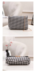 Detail of houndstooth crossbody bag with gold metal chain strap and elegant clasp closure