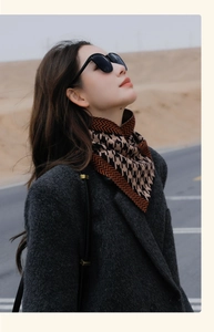Close-up of orange and brown houndstooth pattern scarf with a stylish outdoor desert background