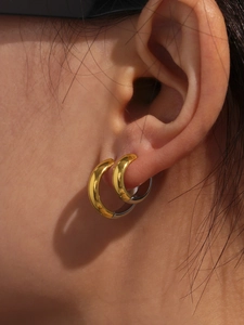 Close-up showing the two-tone 18k gold plated stainless steel hoop earrings on ear