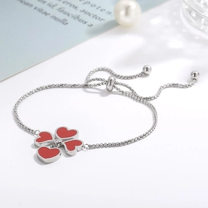 Dettaglio di un bracciale regolabile in argento con quadrifoglio a cuore rosso e zircone