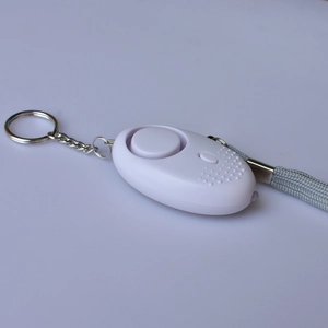 Close-up of white personal safety alarm with LED light, metal keychain and nylon wrist strap