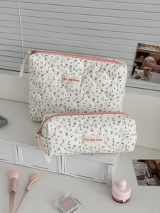 Détail de la trousse de maquillage matelassée avec motif floral pêche élégant
