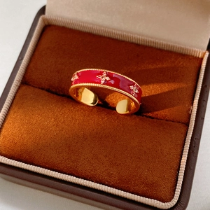 Detailed macro of 18k gold plated ring with red enamel flower and cubic zirconia accents
