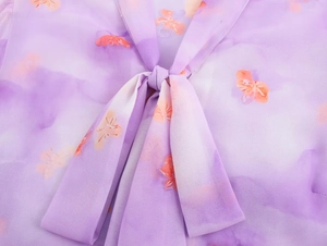 Detail of French style purple floral chiffon blouse with neck tie and ruffle trim