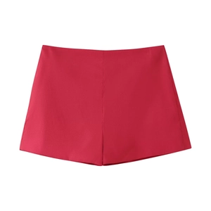 Dettaglio degli shorts a gonna a pieghe rosso acceso a vita alta con finitura invisibile