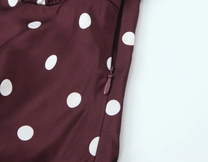 Close-up of invisible side zipper and white polka dots on brown vintage dress