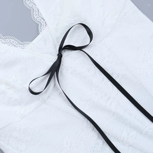 Nahaufnahme eines weißen Spitzentops mit schwarzer Satinschleife und V-Ausschnitt-Details