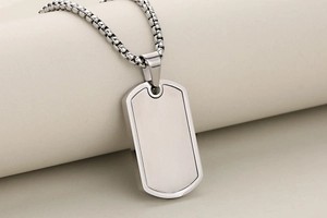 Macro shot of brushed silver stainless steel military dog tag pendant on a box chain
