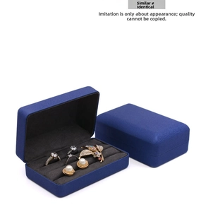 Macro detail of navy blue jewelry storage box with ring slots and grey velvet lining