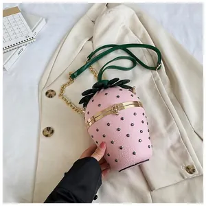 Détail du sac seau fraise rose montrant le cuir litchi et le fermoir en métal doré