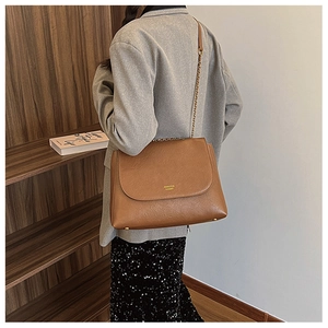 Brown PU leather chain crossbody bag with flap and large capacity shown on model