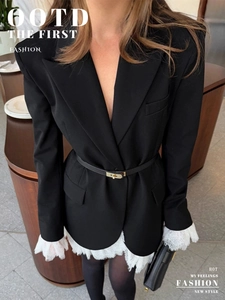 Detailed view of black double-breasted blazer with lace trim and metal buckle belt
