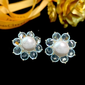 Elegant gold-tone flower earrings with white pearl center and blue crystal petals