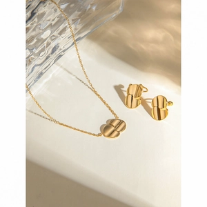 Detailed view of gold geometric layered disc necklace and matching stud earrings set