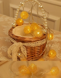 Détail de guirlandes LED de Noël jaunes chaudes avec boules en métal tissé doré