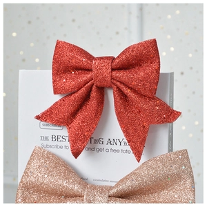Detail of red and champagne gold glitter bow ornaments for festive holiday decoration