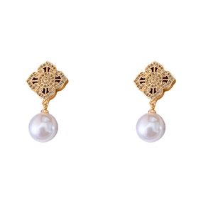 Vintage gold hollow flower earrings with zircon and drop pearl pendants on white background