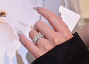 Close-up of wide pavé silver ring with sparkling micro-set crystals on model hand
