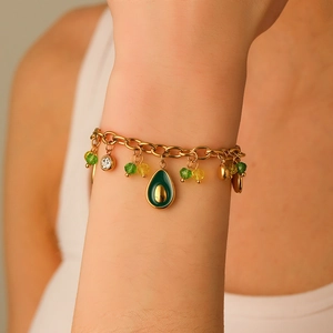 Fashion gold chain bracelet with cute avocado pendant and green crystal beads on model's wrist